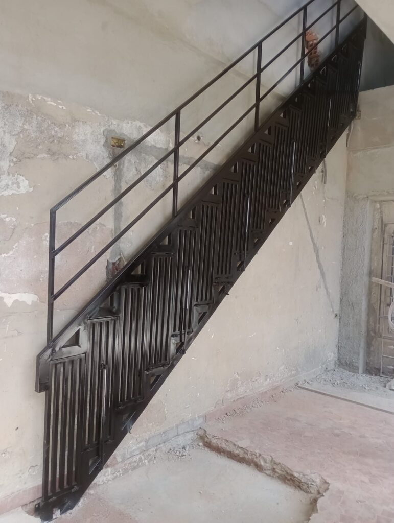 Escada metálica preta com corrimão instalada no Jardim Vazame, Embu das Artes