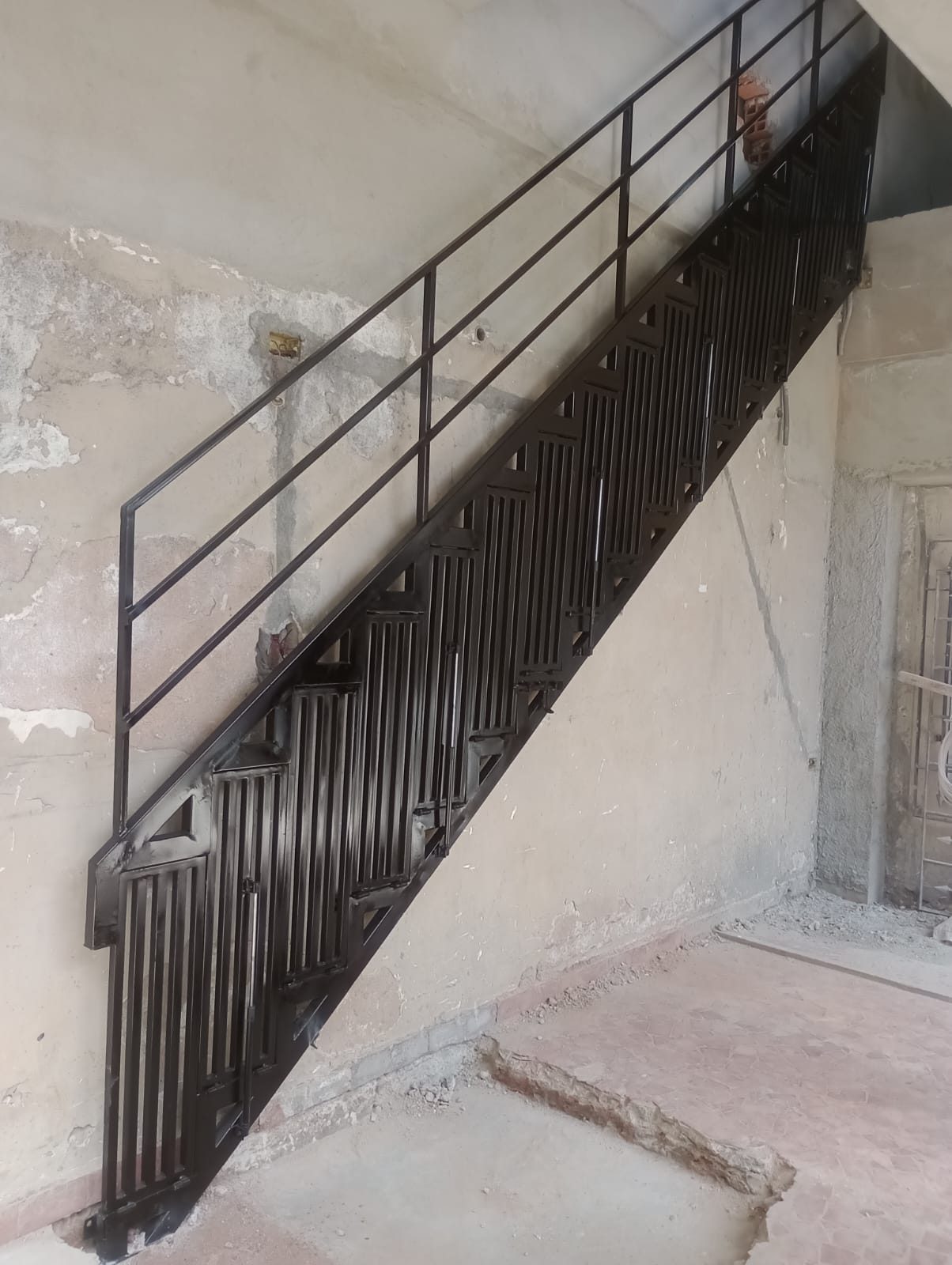 Escada metálica preta com corrimão instalada no Jardim Vazame, Embu das Artes
