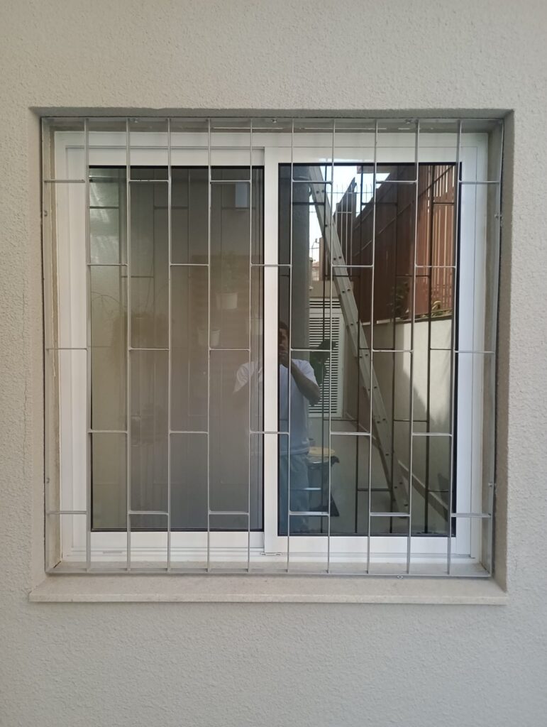 Grade de proteção branca instalada em janela de residência em Indianópolis, São Paulo