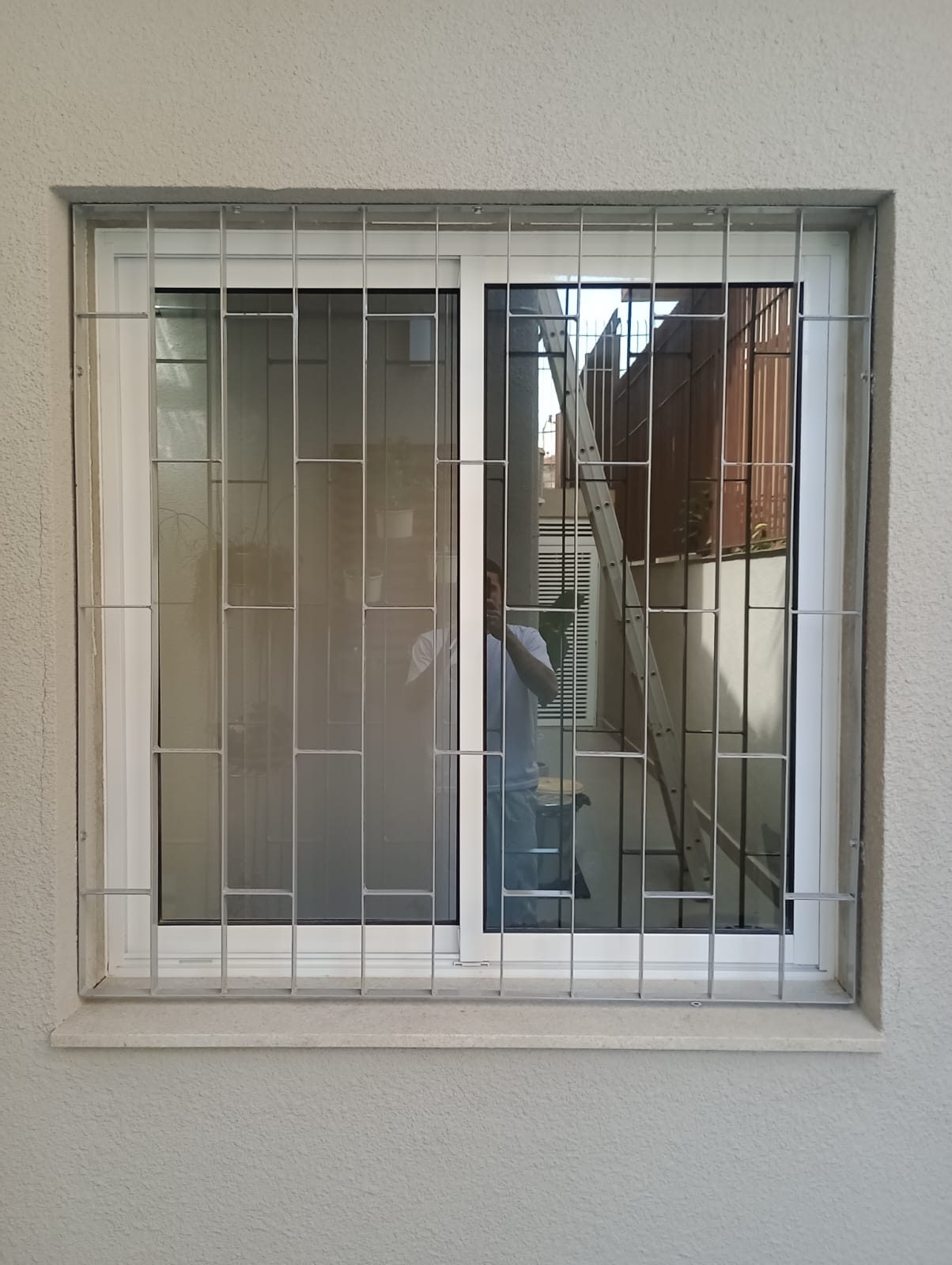 Grade de proteção branca instalada em janela de residência em Indianópolis, São Paulo