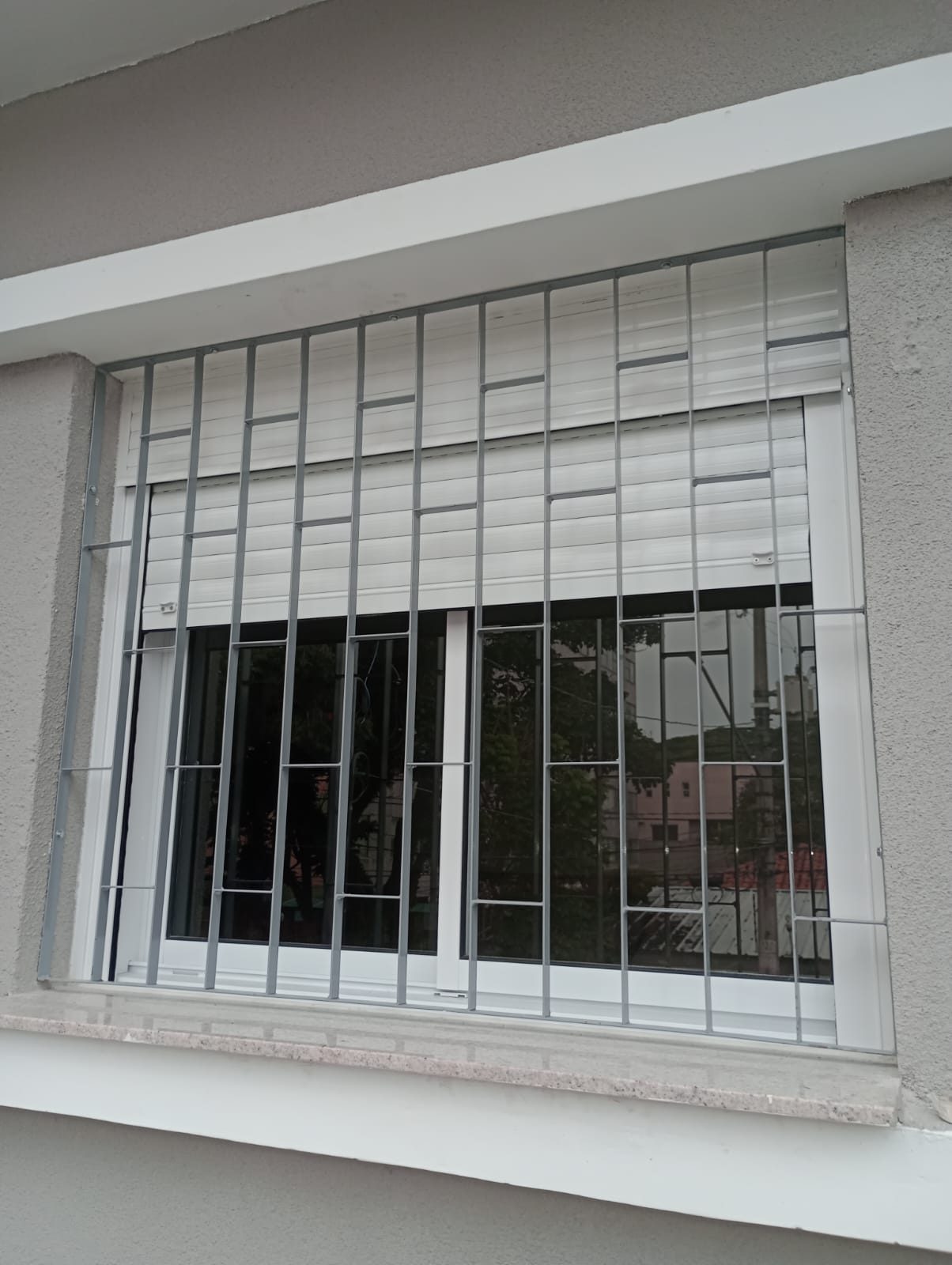 Grade de proteção branca em janela com persiana