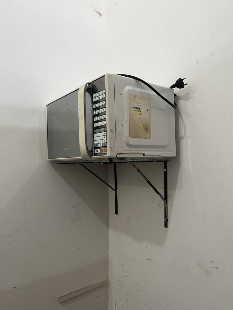 Micro-ondas apoiado em suportes mão francesa de ferro na parede em Embu das Artes