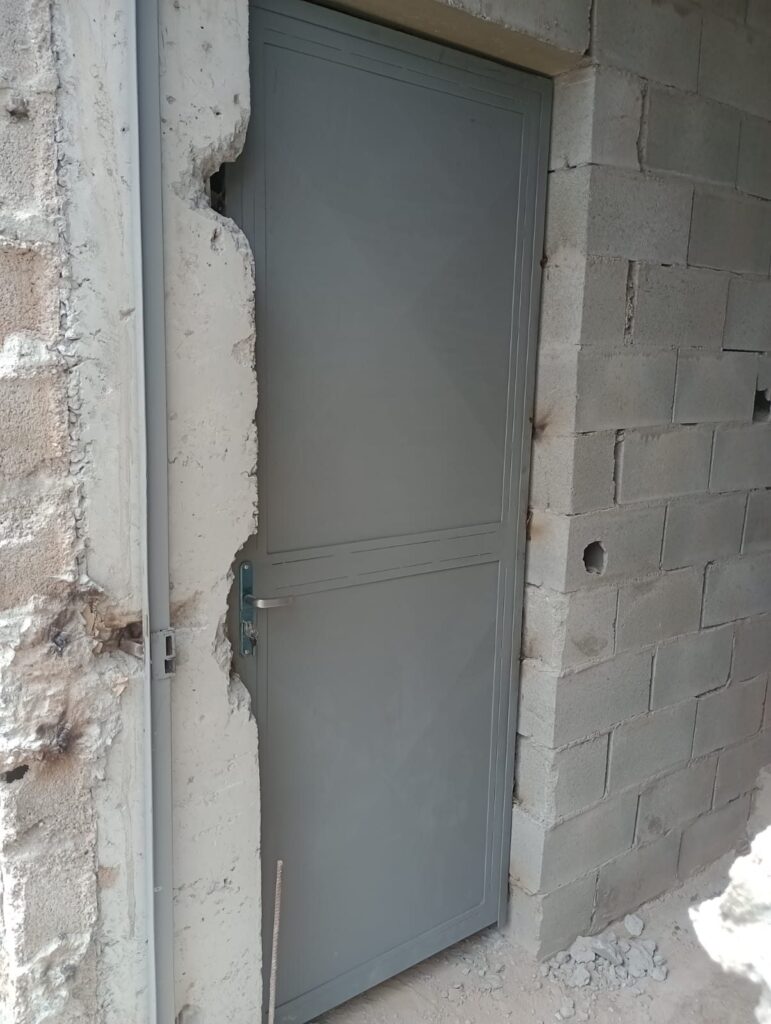 Porta de aço cinza instalada em alvenaria no Valo Velho, Zona Sul de São Paulo