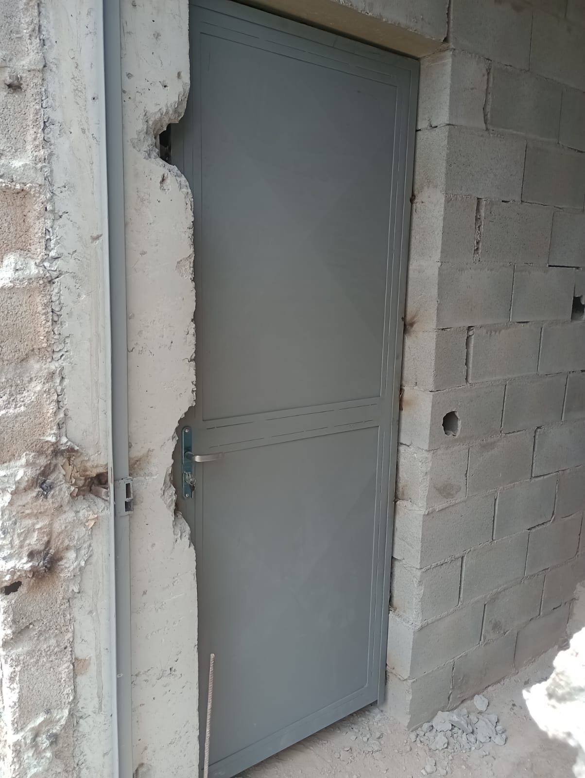 Porta de aço cinza instalada em alvenaria no Valo Velho, Zona Sul de São Paulo